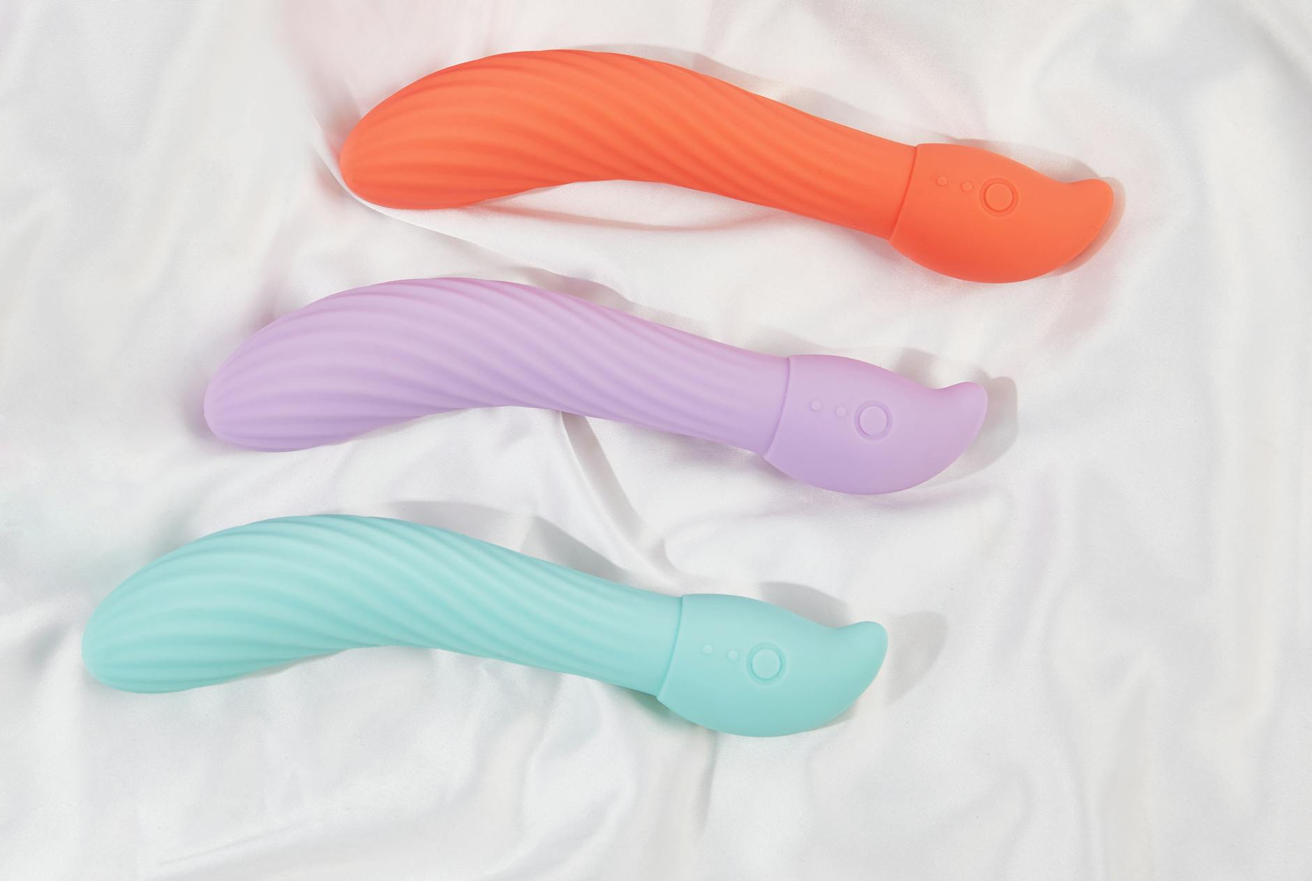 A sleek lemon vibrator resting on white silk fabric
