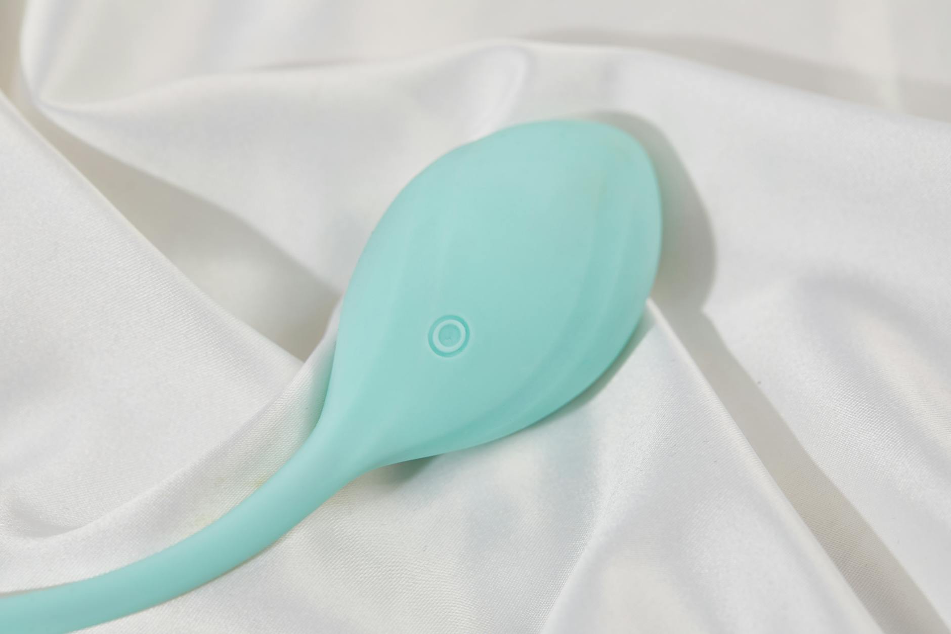 A stylish lemon-colored vibrator resting on soft white fabric, ready for use