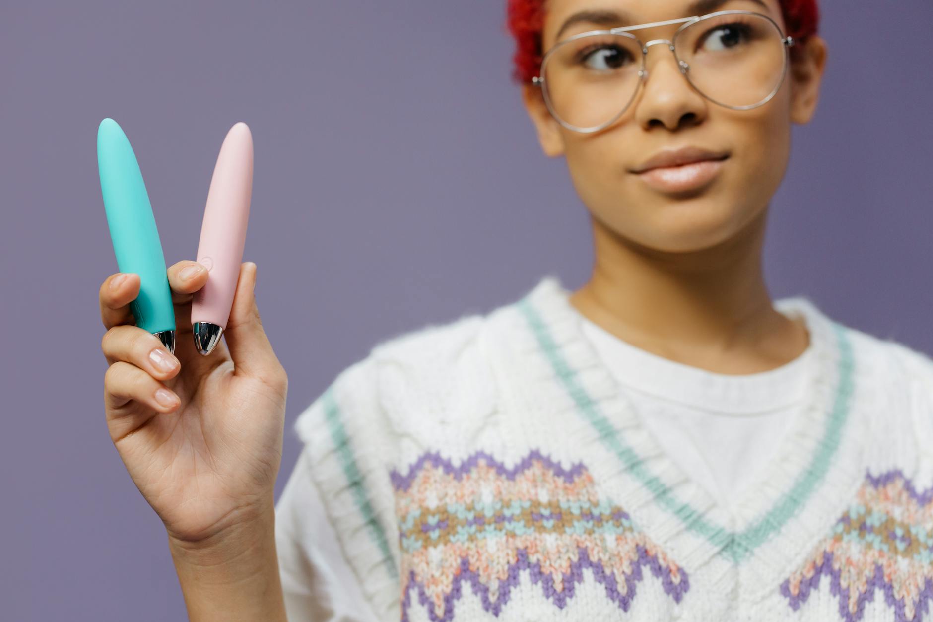 Woman holding colorful vibrators, exploring pleasure and recovery