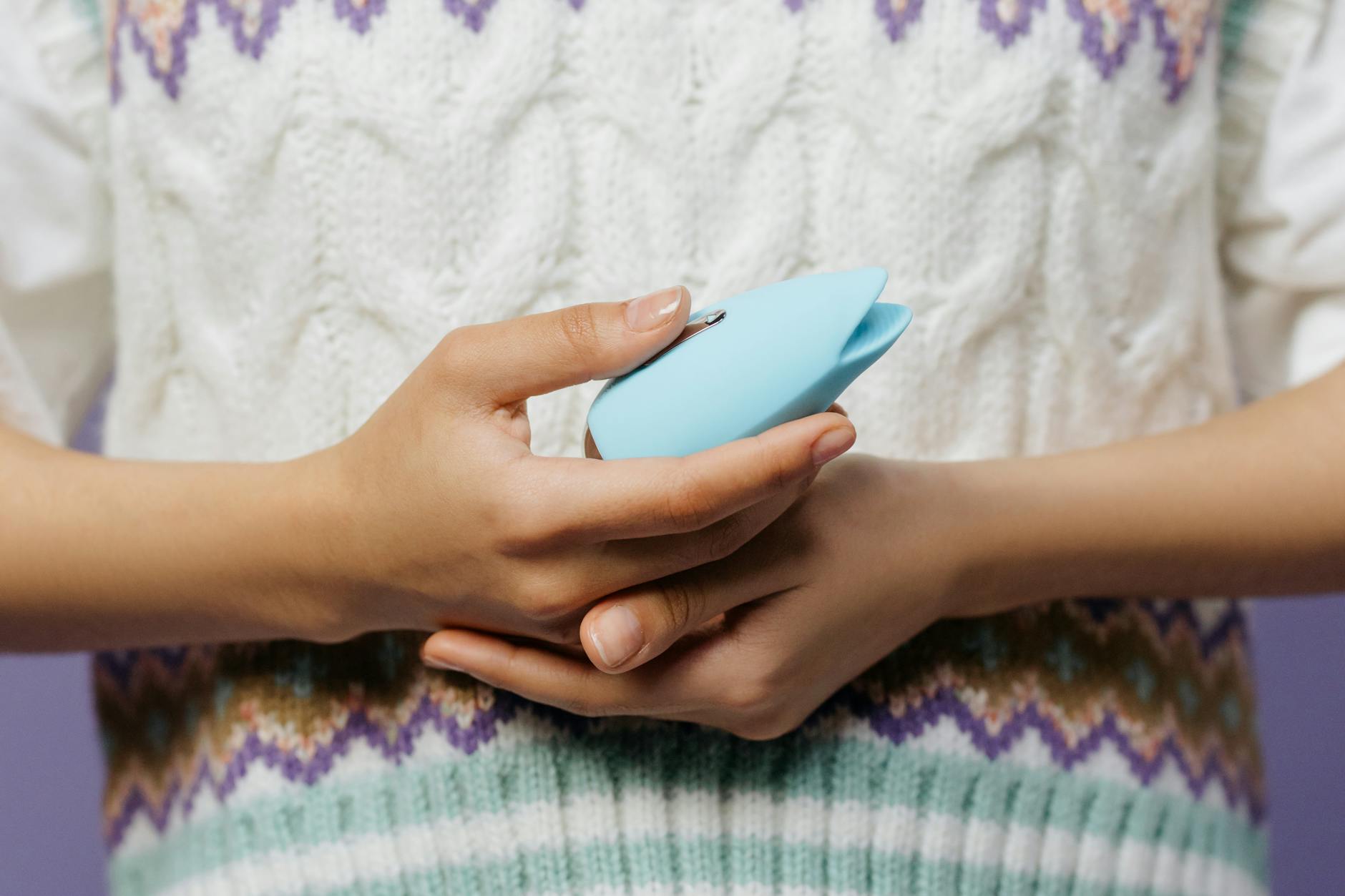 Hands holding a personal massager, representing tactile pleasure recovery